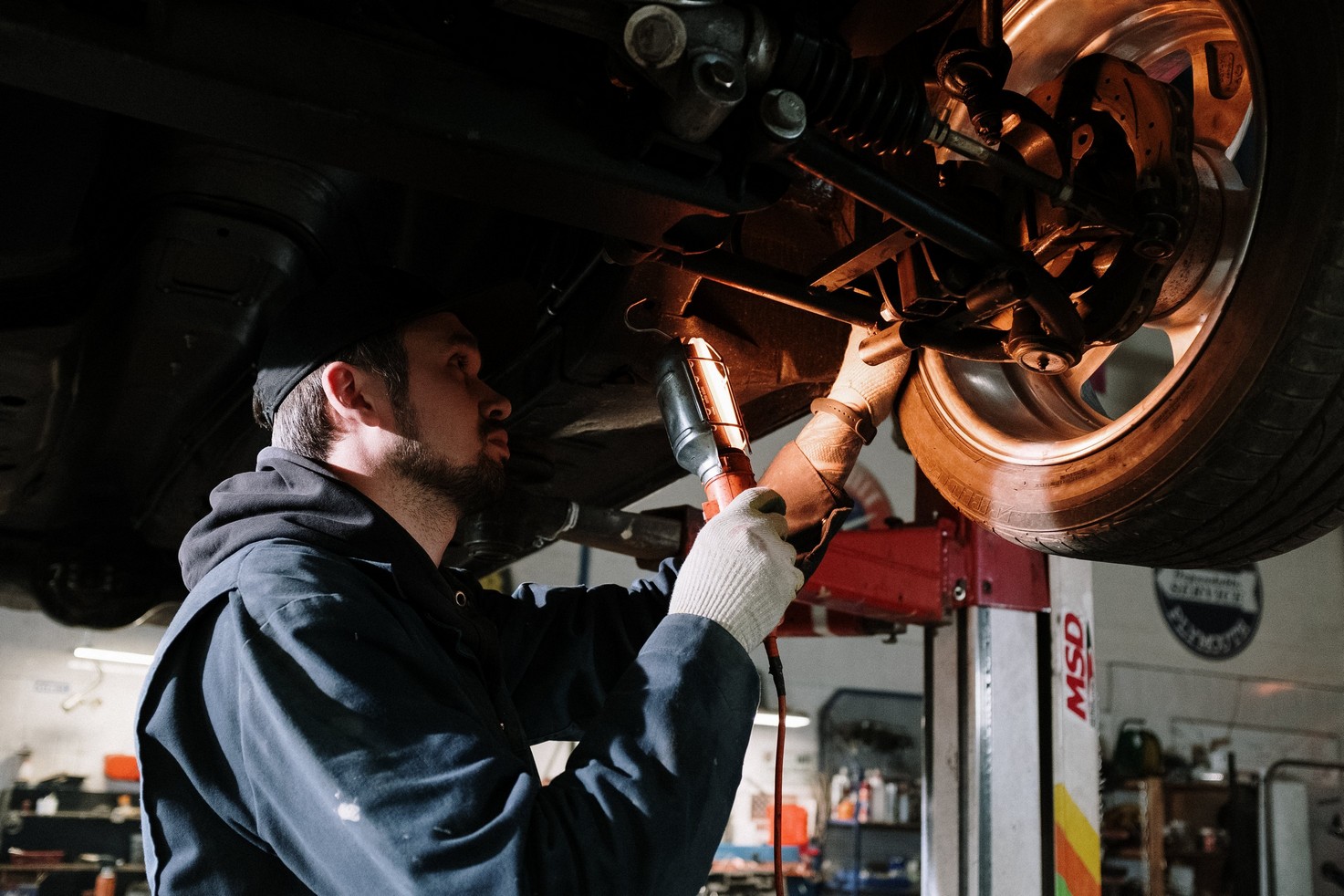 mechanic putting air into a car tire